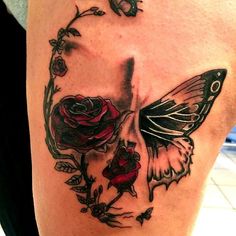 a woman's thigh with a butterfly and roses on it