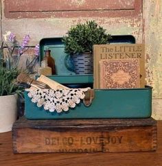 an old wooden box with books and flowers in it sitting on top of a table