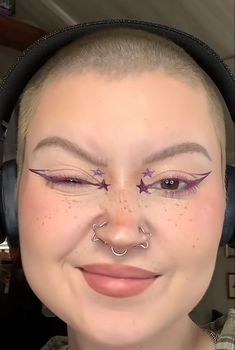 Star Shaped Nose Ring, Graphic Purple Eyeliner, Star Shaped Eyeliner, Star Makeup Inner Corner, Star Graphic Liner Makeup, Graphic Liner Purple, Rock Star Eye Makeup, Symmetrical Nose Piercing, Graphic Liner With Rhinestones