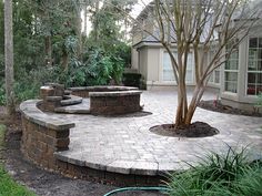 a brick patio surrounded by trees and bushes