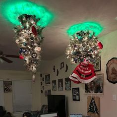 two christmas lights hanging from the ceiling in a living room with pictures on the wall