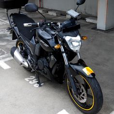 a black and yellow motorcycle parked in a parking lot