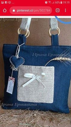 a blue purse with a white bow and ribbon on the front is sitting in hay