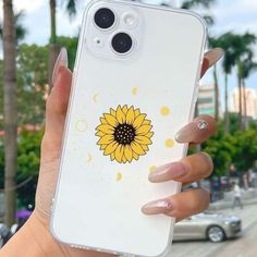 a woman holding up her phone case with a sunflower on it