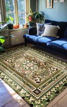 a living room with a blue couch and green rug on the floor next to a window