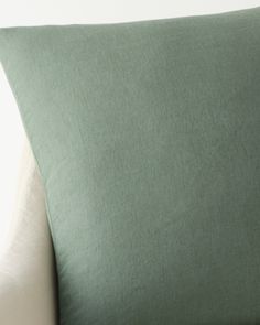 a green pillow sitting on top of a white couch