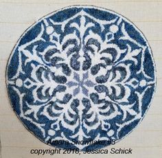 a blue and white plate sitting on top of a table next to a piece of paper