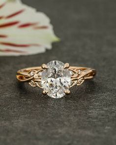 a close up of a ring with a flower in the background