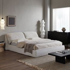 a white bed sitting on top of a wooden floor