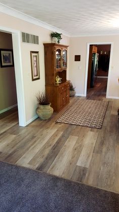 a living room filled with furniture and a rug on top of a hard wood floor