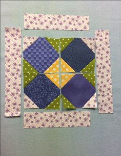 four patchwork squares are arranged on top of each other, with one block in the middle