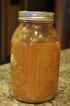 a glass jar filled with liquid sitting on top of a counter