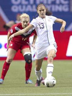 two women are playing soccer on the field