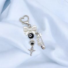 a keychain with charms attached to it sitting on a white cloth covered surface