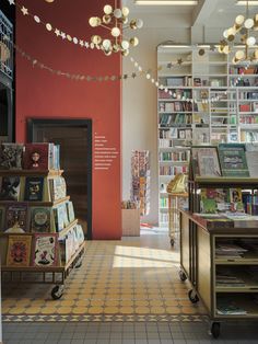 the inside of a bookstore with many books on shelves and lights hanging from the ceiling