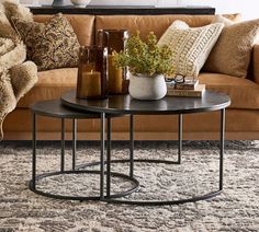 a living room with a couch, table and vases on the coffee table in front of it