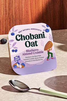 a close up of a spoon on a table next to a container of chobani oat