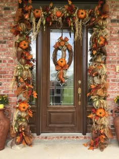 a front door decorated for fall with pumpkins and gourds