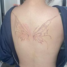 a woman with a butterfly tattoo on her back