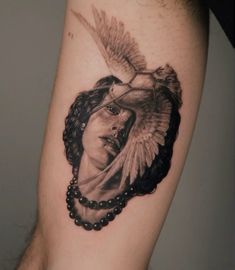 a woman's arm with a tattoo on it that has a bird flying over her head