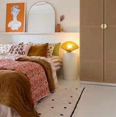 a bed room with a neatly made bed and a large mirror on the wall above it