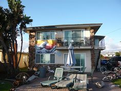 an apartment building with lawn chairs and umbrellas