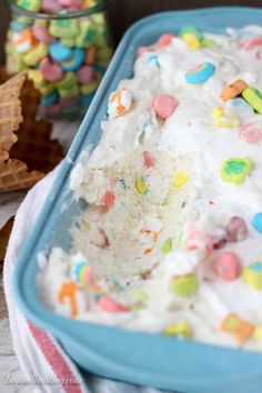 a blue dish filled with ice cream and sprinkles next to some cookies