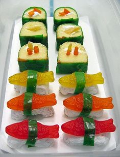 several sushi rolls are arranged on a white platter with green and orange strips