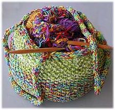 a multicolored bag with wooden handles and yarn in the bottom, on a gray background