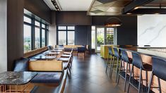 an empty restaurant with marble counter tops and bar stools in front of large windows