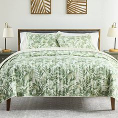 a bed in a bedroom with palm leaves on it