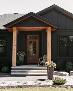 a black house with a wooden porch and front door