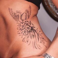 a woman's lower back tattoo with flowers and birds on her stomach, in black and white