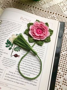 an open book with crocheted flowers on it and the title rose written in english