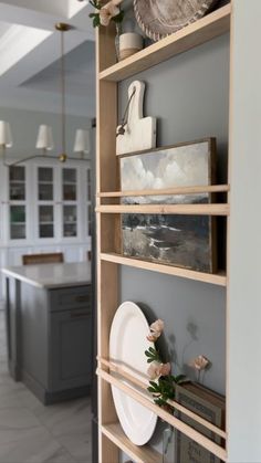 the shelves in this kitchen are filled with plates and vases