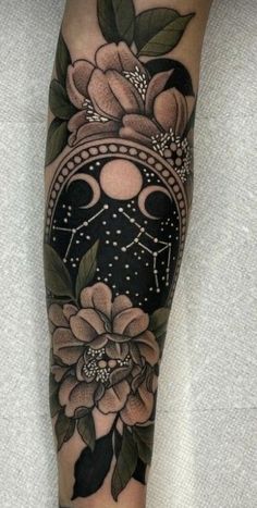 a woman's leg with flowers and a mask tattoo on her arm, which is decorated