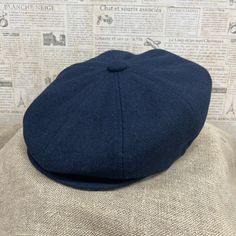 a blue hat sitting on top of a mannequin's head in front of a wall