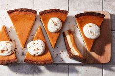 four slices of pumpkin pie with whipped cream on top