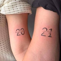 two people with matching tattoos on their arms, one has the number twenty and the other is