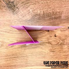 an origami airplane sitting on top of a wooden table