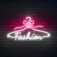 Fashion Neon Signs Clothing Store Led Light The neon sign is a vibrant and eye-catching display, perfect for a fashion boutique. It features a stylized clothes hanger glowing in bright pink neon, with the word “Fashion” elegantly written in cursive script across the hanger. Above the hanger, a blue neon bow adds a touch of sophistication and charm. The neon lights cast a soft glow on the surrounding dark brick wall, creating a trendy and inviting atmosphere. This combination of colors and design elements effectively communicates the store’s focus on fashion and style, making it an attractive and memorable sign for potential customers. Specifications Size (Length x Height): 17" x 10" | 21" x 12" | 25" x 14" | 29" x 17" | 33" x 19" or Your Custom Size Neon Bows, Neon Open Sign, Pink Neon Sign, Neon Bar Signs, Neon Sign Art, Neon Sign Shop, Neon Logo, Cursive Script, Restaurant Signs