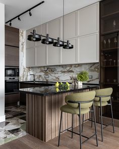 a modern kitchen with marble counter tops and white cabinets