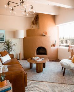 a living room filled with furniture and a fire place in the middle of the room