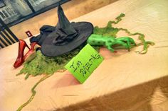 a witches hat on top of a table next to a sign that says i'm dead