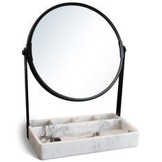 a mirror and jewelry tray on a white surface with a black stand holding it up