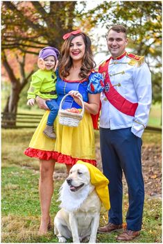 a man, woman and child posing for a photo with a dog