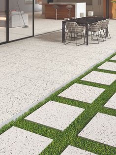 an outdoor patio with grass and chairs