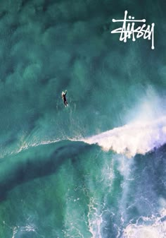 an aerial view of a surfer riding a wave in the ocean with graffiti written on it