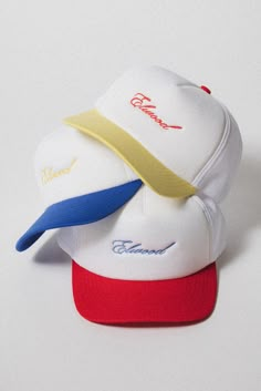 You can never have too many. The Script Trucker Cap has a high crown design with a snapback closure. The front features our Elwood logo in cursive. Available in Red/White, Yellow/White, and Blue/White. 70 DENIER INTERLOCK, 3 OZ FOAM FRONT WITH ELWOOD EMBROIDERY MESH TOP PLASTIC SNAP STRIP ADJUSTER White Retro Snapback Hat With Curved Brim, Graphic Hats, Yellow Trucker Hat With Flat Brim For Streetwear, White Retro Baseball Cap For Streetwear, White Retro Baseball Cap With Letter Print, Retro White Dad Hat, Retro White Snapback Baseball Cap, Playful Cotton Snapback Trucker Hat, Trendy Yellow Snapback Trucker Hat