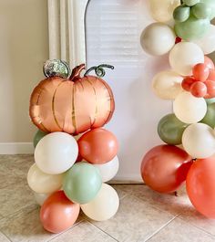 a balloon arch is decorated with balloons and a pumpkin